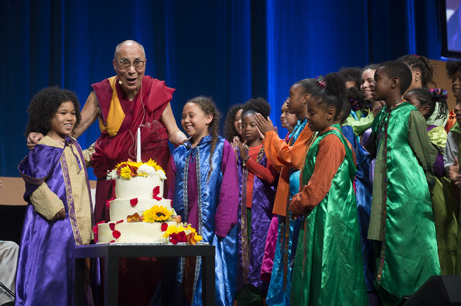His Holiness the Dalai Lama with children of the Agape Choir after blowing out candles on a cake presented on his 80th birthday during the Global Compassion Summit at the the University of California Irvine in Irvine, California on July 6, 2015. (Photo courtesy/Tenzin Choejor/OHHDL)