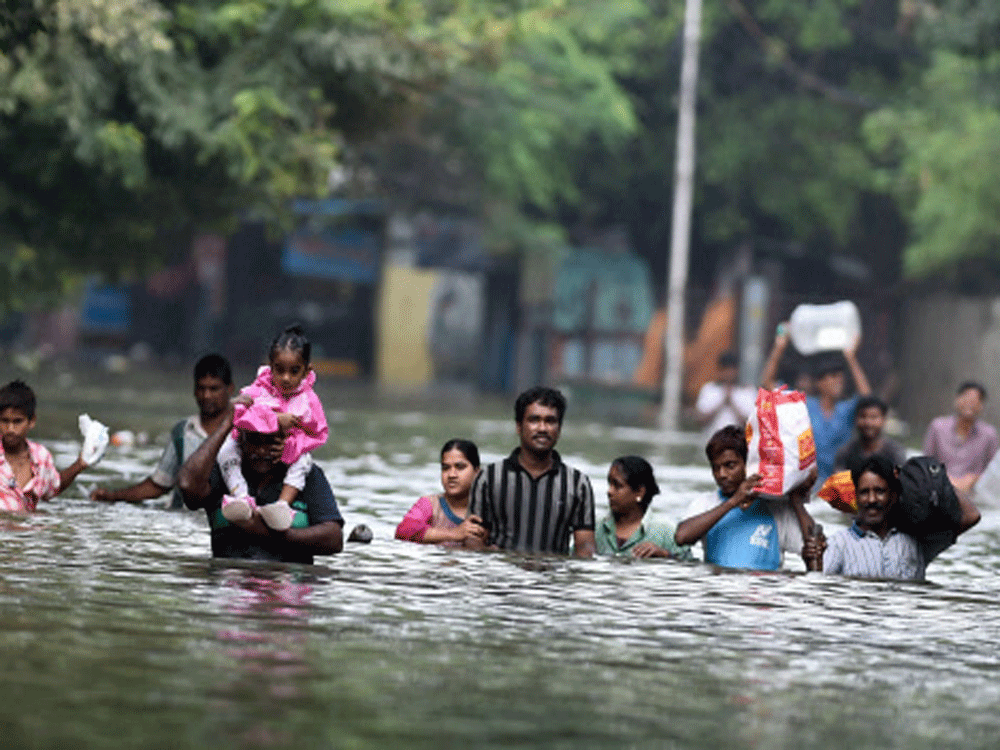 Chennai: People wade through flood waters in rain-hit Chennai on Thursday. (Source: PTI photo)