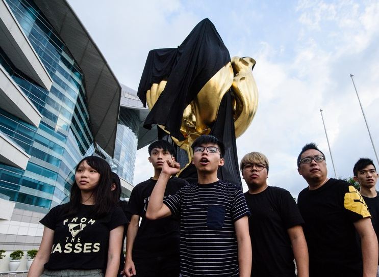 Days ahead of Chinese President Xi Jinping’s visit to Hong Kong for its 20th anniversary of handover from British rule, pro-democracy protesters have on Jun 25 draped a black flag over a statue symbolising the event.  (Photo courtesy: SCMP)