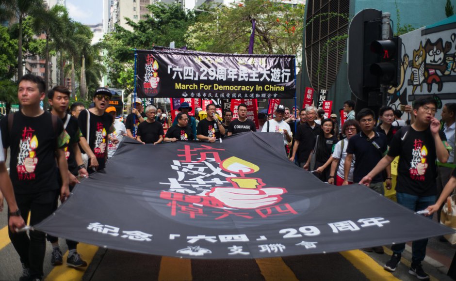 Protesters hold a banner (C) which reads "March For Democracy in China" as they take part in a march in Hong Kong on May 27, 2018 to commemorate the June 4, 1989 Tiananmen Square crackdown in Beijing. Hundreds marched through Hong Kong on May 27 ahead of the 29th anniversary of China's crackdown on democracy protesters in Beijing's Tiananmen Square. (Photo courtesy: Anthony Wallace / AFP)